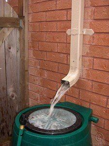 a green barrel with water coming out of it