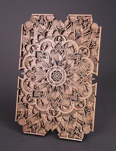 an intricately carved wooden plaque with flowers and leaves on the front, sitting on a gray surface