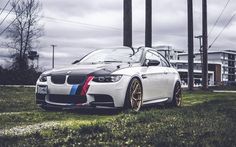 a white car parked on top of a lush green field