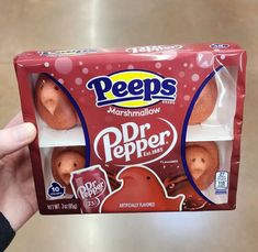 a hand holding a box of peeps marshmallows