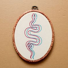 an embroidery pattern is shown in the shape of a snake