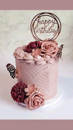 a birthday cake decorated with pink flowers and butterflies