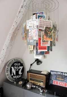 an old radio sits on top of a dresser in a room with posters hanging from the ceiling