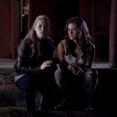 two young women sitting on steps in the dark