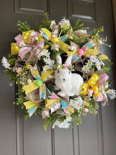 a wreath with a white teddy bear on it