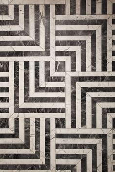 a black and white marble floor with an abstract design in the center that looks like a maze