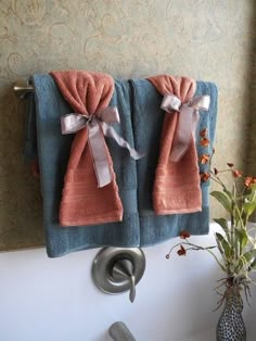 two towels hanging on the side of a sink