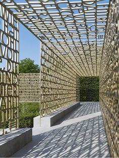 an intricately designed pergolated walkway in the middle of a park