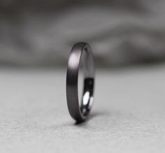 a close up of a wedding ring on a white surface with the background blurry