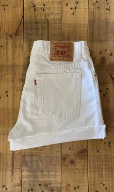 "High waisted 90's denim shorts. Made by Levi's Jeans in classic white denim wash. Shorts are in excellent clean condition. Perfectly worn in with light naturally distressed character. These have been cut off and washed once. Measurements are taken zipped or buttoned up and laid comfortably flat then x 2 for total circumference (inches) Tag Size 12 100% Cotton ~ Measurements taken 'un' rolled Waist 34\" Hips 45.5\" Length 15\" Inseam 4\" Rise 11\" leg opening circumference 26.5\" All items are f Cheap Light Wash Jean Shorts With Button Closure, White Levi's Jean Shorts, Cheap Levi's White Jeans, Retro White Shorts With Pockets, White High Waist Jean Shorts With Belt Loops, White Cotton Jean Shorts With Belt Loops, Retro Cotton Cutoff Shorts, Vintage High Waist White Shorts, Vintage White Jean Shorts For Spring