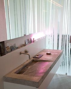 a bathroom sink sitting under a mirror next to a wall mounted toothbrush dispenser