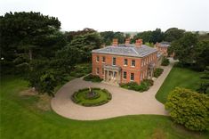 an aerial view of a large red brick house