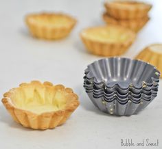 several small pie pans lined up on a white counter top, with one half eaten