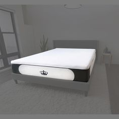 a bed with a black and white mattress on it in a room next to a window