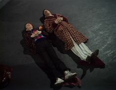 two people laying on the ground next to each other