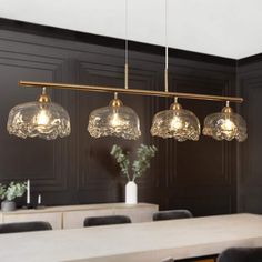 three lights hanging over a dining room table