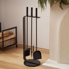 a black chair sitting in front of a fireplace next to a potted plant and mirror