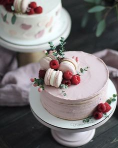 a cake with raspberries and macaroons on top