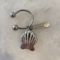 a silver key chain with a shell on it