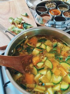 a pot filled with vegetables on top of a stove next to other cooking utensils