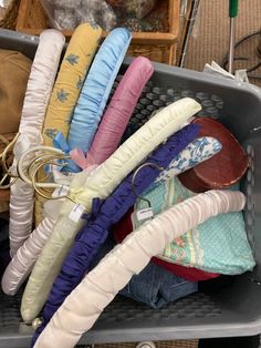 a basket filled with lots of different colored umbrellas next to a pile of other items