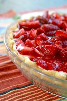 a pie with strawberries in it sitting on a table