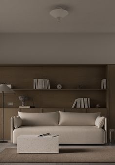 a living room with a couch, lamp and bookshelf on the wall behind it