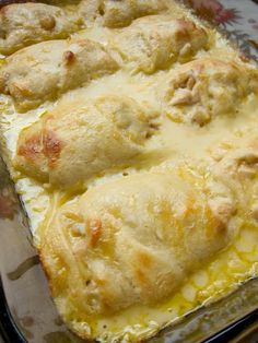 a casserole dish with meat and cheese in it sitting on a glass pan