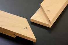 two pieces of wood sitting next to each other on a black surface with one piece missing