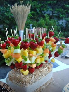 fruit skewers are arranged on top of straw