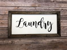 a sign that says laundry hanging on a wooden wall