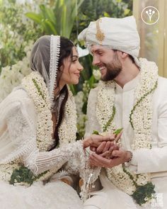 a man and woman dressed in white sitting next to each other