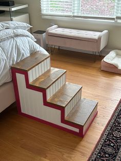 a bed room with a neatly made bed and steps leading up to the top floor