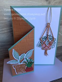 a handmade card with a hanging planter and potted plants