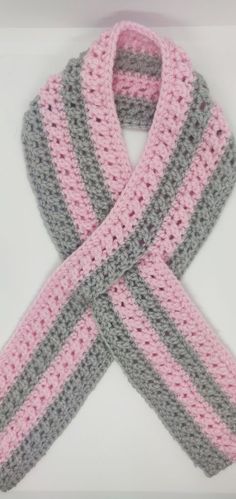 a crocheted scarf with pink, grey and white stripes