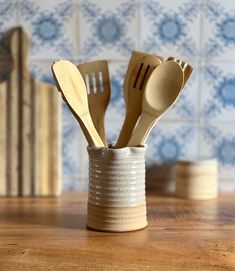 wooden spoons and forks in a cup on a table