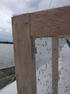 there is a screen on the side of a boat that has water behind it and clouds in the sky