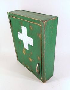 an old green medicine cabinet with a white cross on it