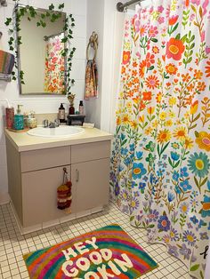 a bathroom with a colorful rug and shower curtain