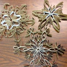 four paper snowflakes sitting on top of a wooden table