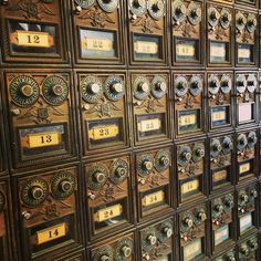 many mail boxes are lined up on the wall