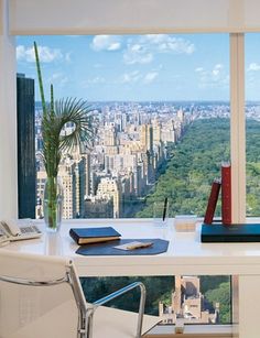 an office desk with a view of the city from it's high rise window