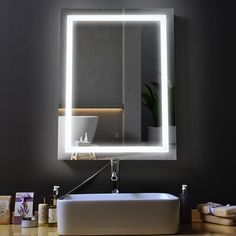 a bathroom sink with a lighted mirror above it