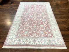 a pink and white rug on the floor in a room with hardwood floors, furniture and accessories