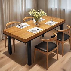 a dining table with four chairs and a vase filled with flowers on top of it