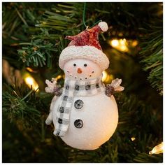 a snowman ornament hanging from a christmas tree