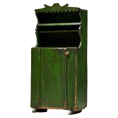 an old green wooden cabinet with two doors on the front and one door open to reveal a