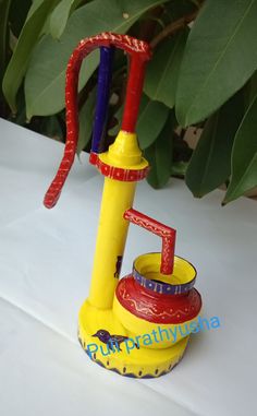 a yellow and red object sitting on top of a white table next to green leaves