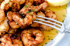 a plate full of shrimp with lemon wedges