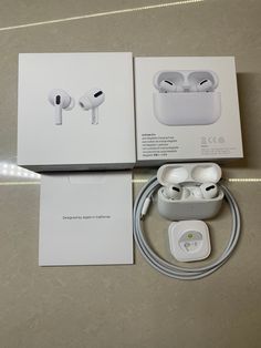 two apple airpods sitting next to each other on top of a table with packaging